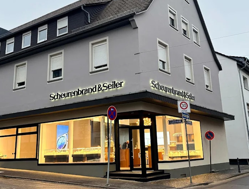 Ein weißes Gebäude mit großen Fenstern und der Aufschrift "Scheurenbrand & Seiler".