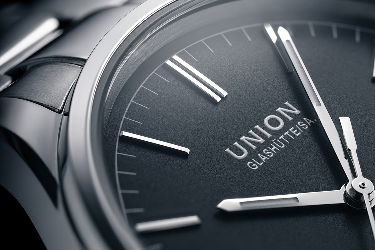 Nahaufnahme einer eleganten Uhr mit grauem Zifferblatt und silbernen Zeigern