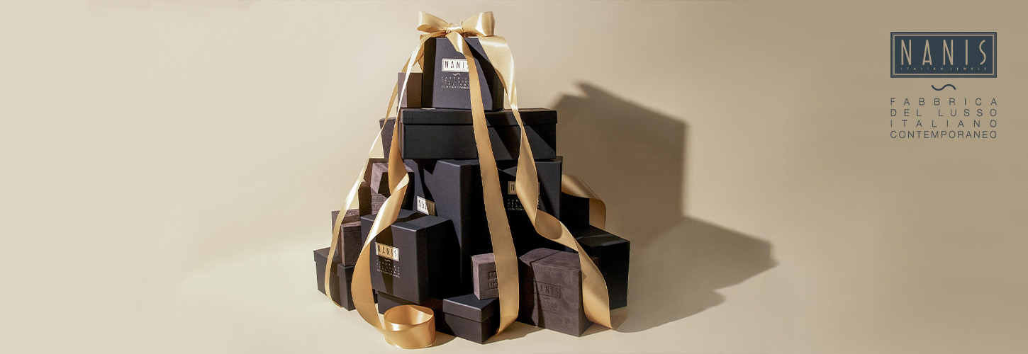 Viele elegante schwarze Geschenkboxen mit goldener Schleife vor beigem Hintergrund