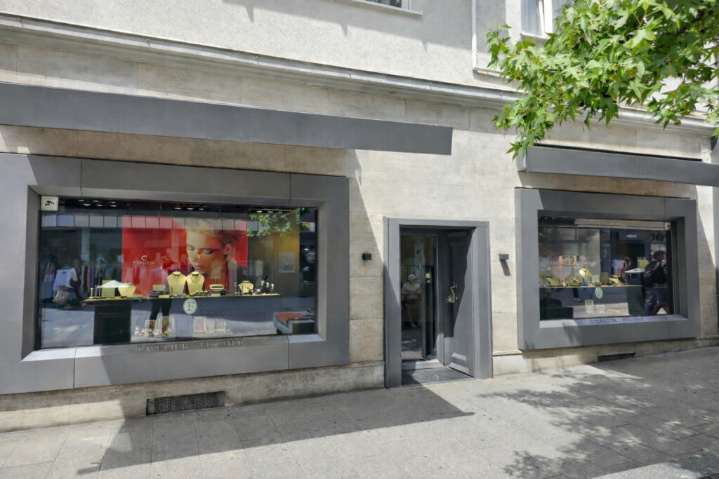 Ein Juweliergeschäft mit großen Schaufenstern, gelbem Schmuck und heller Reklame