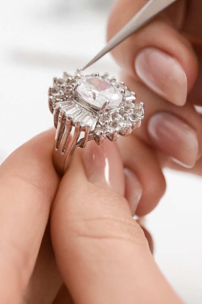 Goldschmiedin bei der Herstellung eines Rings auf einem weißen Tisch, Nahaufnahme