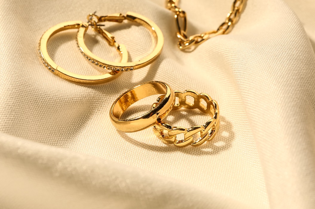 Wunderschöner goldener Schmuck vor weißem Stoffhintergrund