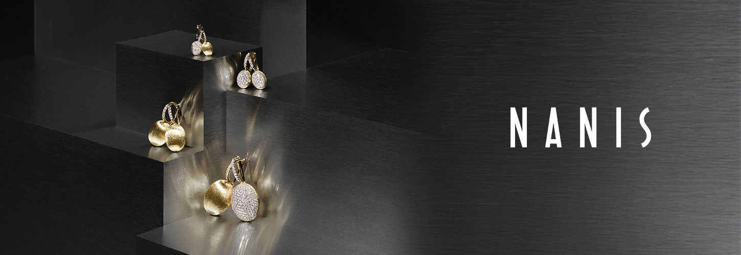 Mehrere goldene und diamantbesetzte Ohrringe mit organischer Form auf dunklen Stufen
