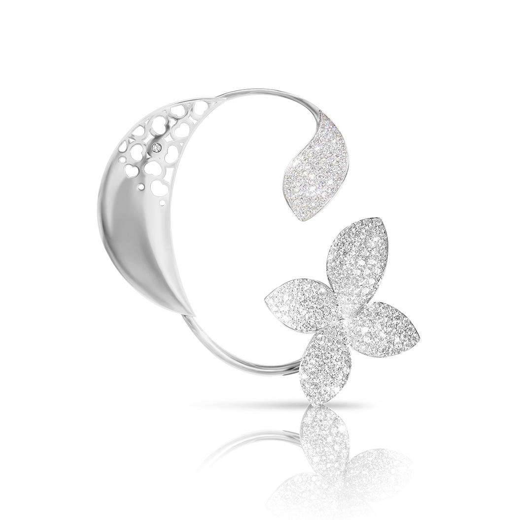Ein silbernes Schmuckstück mit glitzerndem Blatt und funkelnder Blumenform