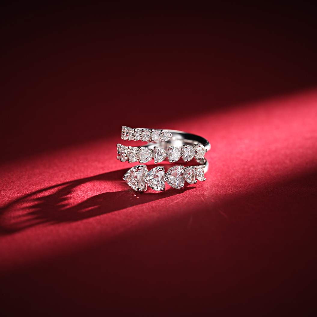 Ein silberner Ring mit mehreren Reihen funkelnder Diamanten liegt auf rotem Untergrund