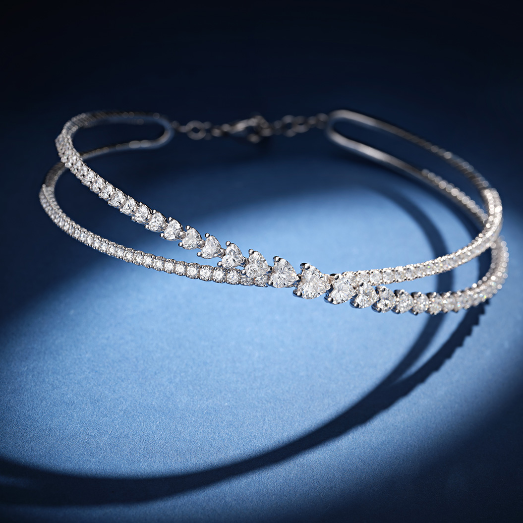Eine elegante Halskette mit funkelnden, tropfenförmigen Diamanten auf dunklem Blau