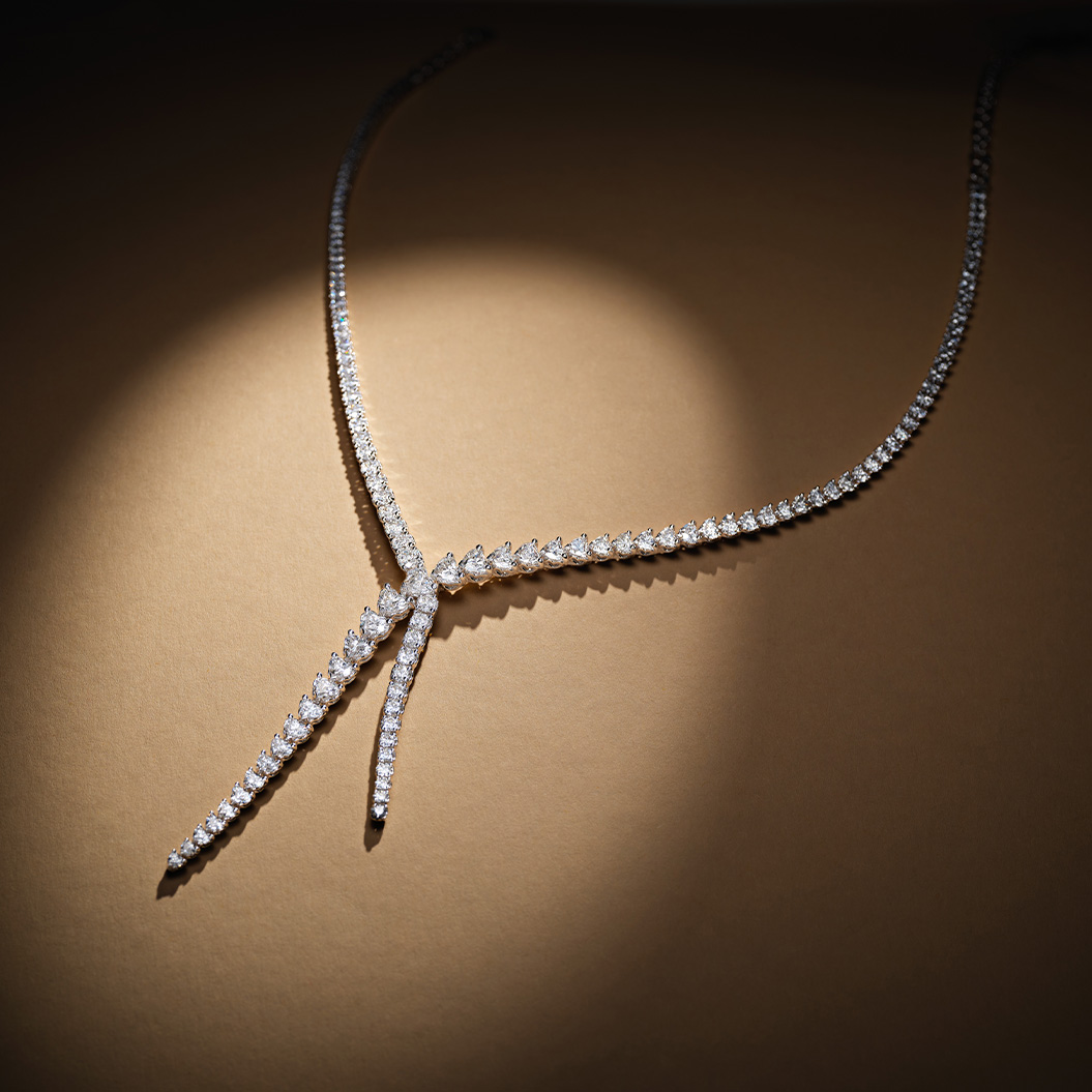 Eine elegante diamantbesetzte Halskette funkelt auf einem goldbraunen Untergrund