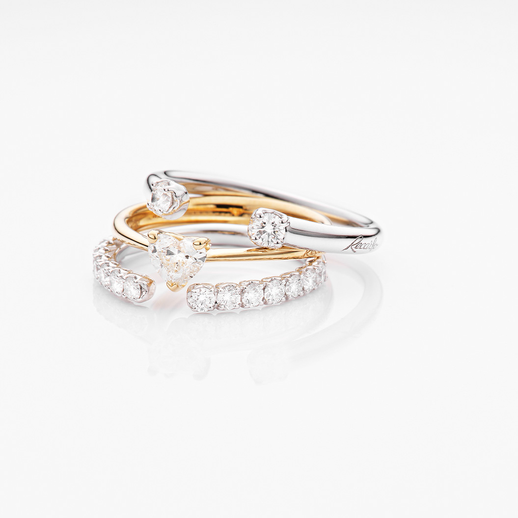 Drei edle Ringe aus Gold und Silber mit auffälligen Diamanten auf weißem Hintergrund