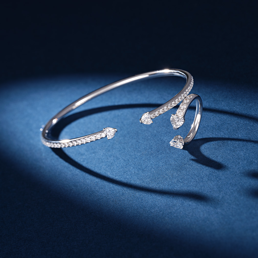 Ein funkelndes Silberarmband mit Diamanten liegt elegant auf dunkelblauem Hintergrund