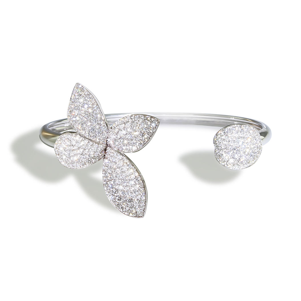 Eine elegante silberne Armspange mit glitzernden Blumen und einem runden Element