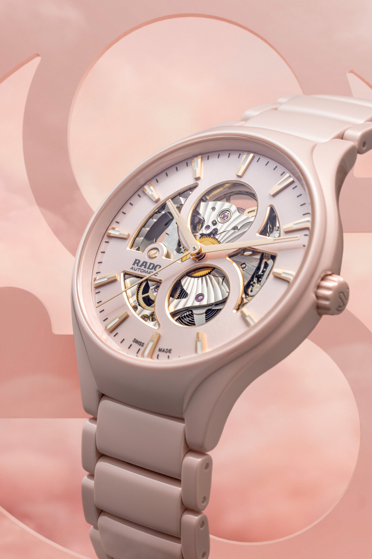 Elegante rosafarbene Uhr mit offenem Zifferblatt und glänzenden Details, neutral