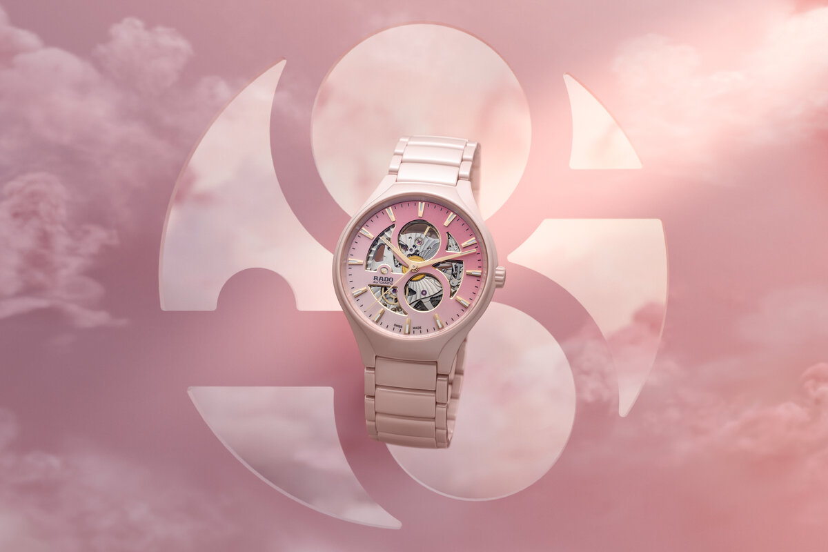 Rosafarbene Armbanduhr mit Metallband vor rosa Wolken und Symbolhintergrund