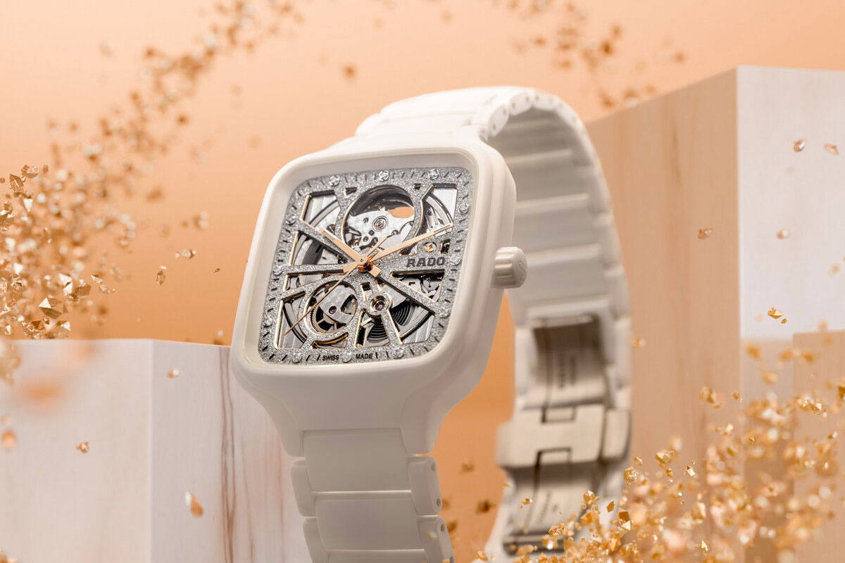 Weiße Armbanduhr mit skelettiertem Zifferblatt und goldenen Akzenten